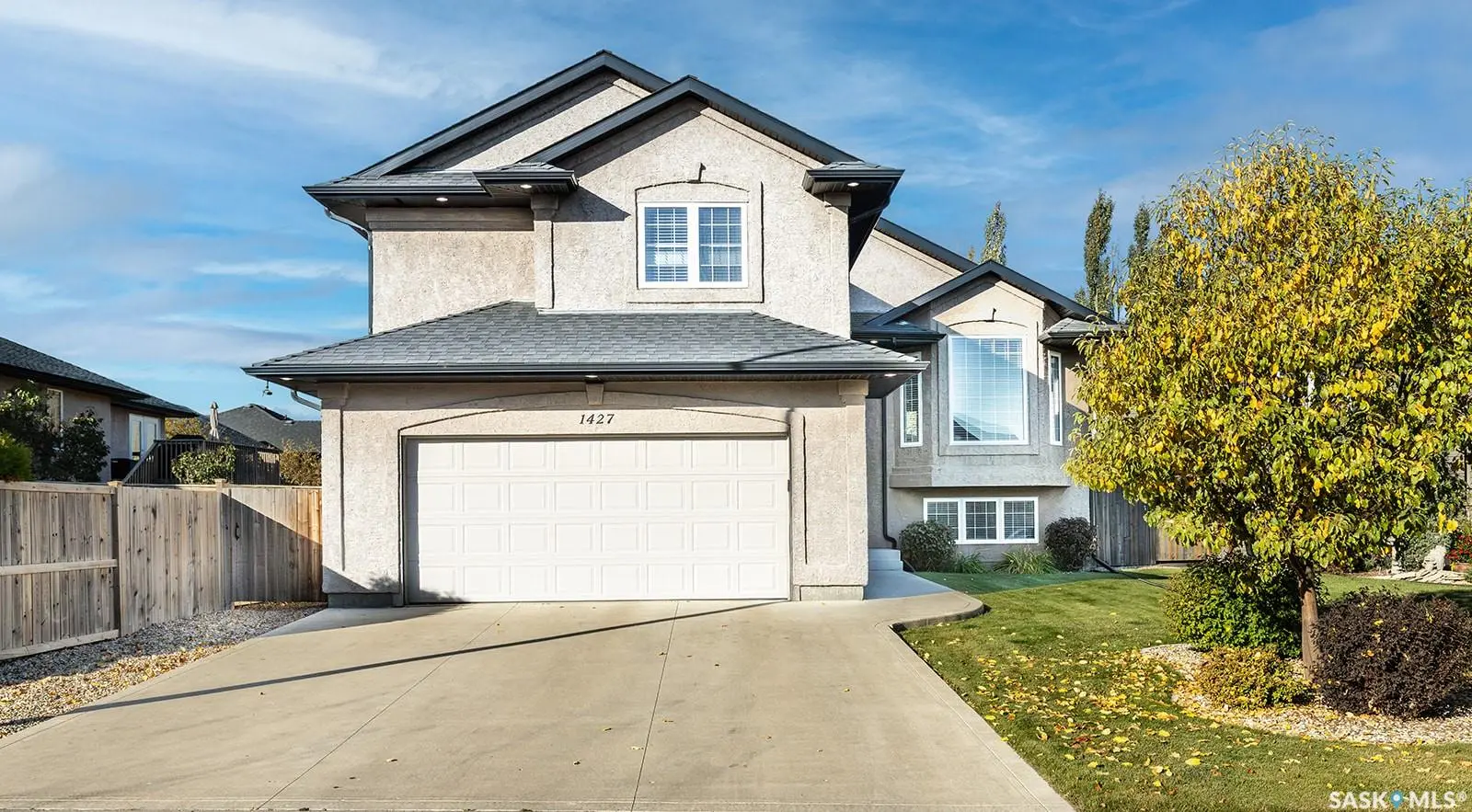 Exterior photo of 1427 Shepherd Lane, Saskatoon SK showing a modern bi-level home with a landscaped front yard.